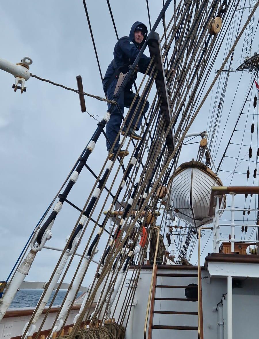 Sail trainee climbing ship